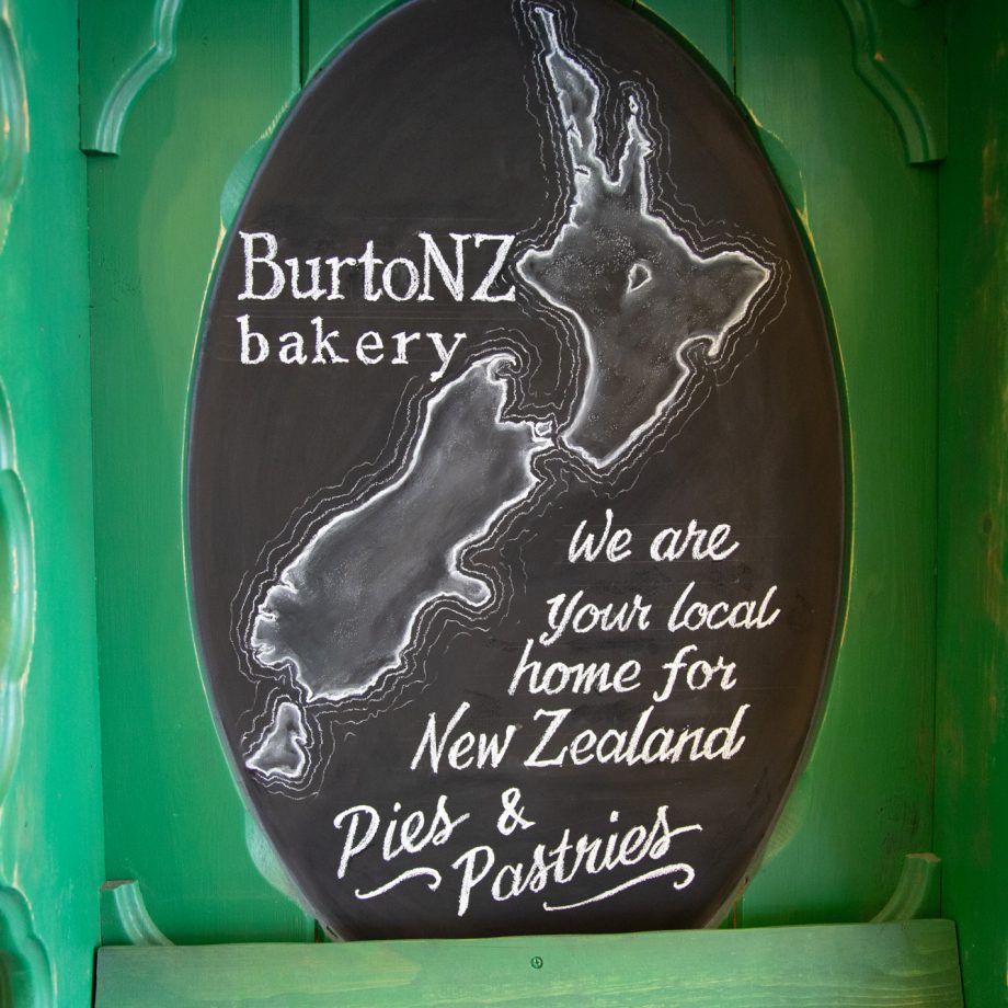 A green board with welcome text to BurtoNZ Bakery